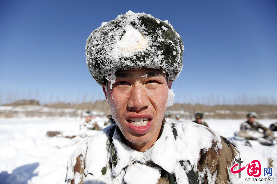  2015年3月2日，黑龙江省军区某边防团机动步兵连官兵冒着－15℃严寒气温组织开展腹部抱圆木仰卧起训练，一名战士的衣服、脸颊被冰雪覆盖。中国网图片库 魏建顺/摄