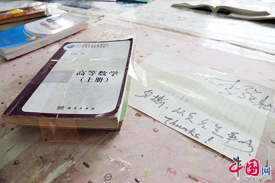 　　　2015年3月4日，河南省郑州市，占座学生出奇招，将书本用透明胶带牢牢粘在桌子上，并留下占座“宣言”。中国网图片库 供图