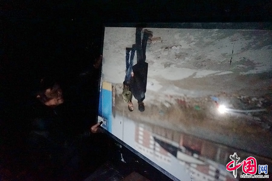 3月7日，在河南省焦作市，一台总长13米的超级照相机亮相街头。图为李宗泽（左一）介绍他拍的测试样片。中国网图片库 龙邦/摄
