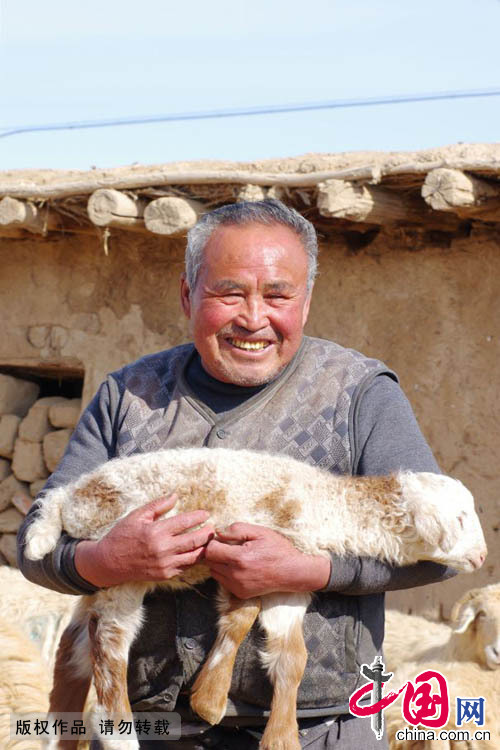  2015年3月9日，呂吉弟開心地抱住剛生下有1個月的羊羔。羊多了，家裏的收入就多了，這讓呂吉弟異常的開心。中國網圖片庫