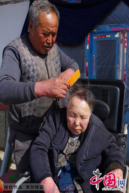  2015年3月9日，每當中午陽光燥熱時，呂吉弟都會推著輪椅，在院內和妻子説説話，幫妻子梳理為數不多的頭髮。