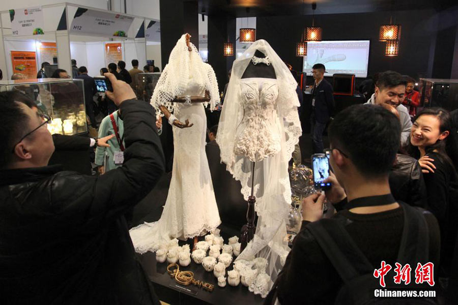 3月12日，亚洲3D打印、增材制造展在上海开幕。现场两套由3D打印机打印出来的婚纱礼服夺人眼球。据悉，此类3D婚纱是由尼龙粉打印制成，与普通婚纱一样柔软耐用。一件头纱的打印时间需要耗时一周，成本价在2万人民币左右，价格昂贵。中新社发张亨伟 摄