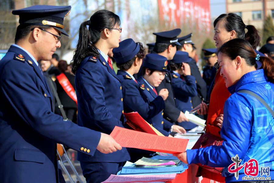 圖為3月15日，甘肅張掖市甘州區工商局執法人員在為群眾發放宣傳資料。