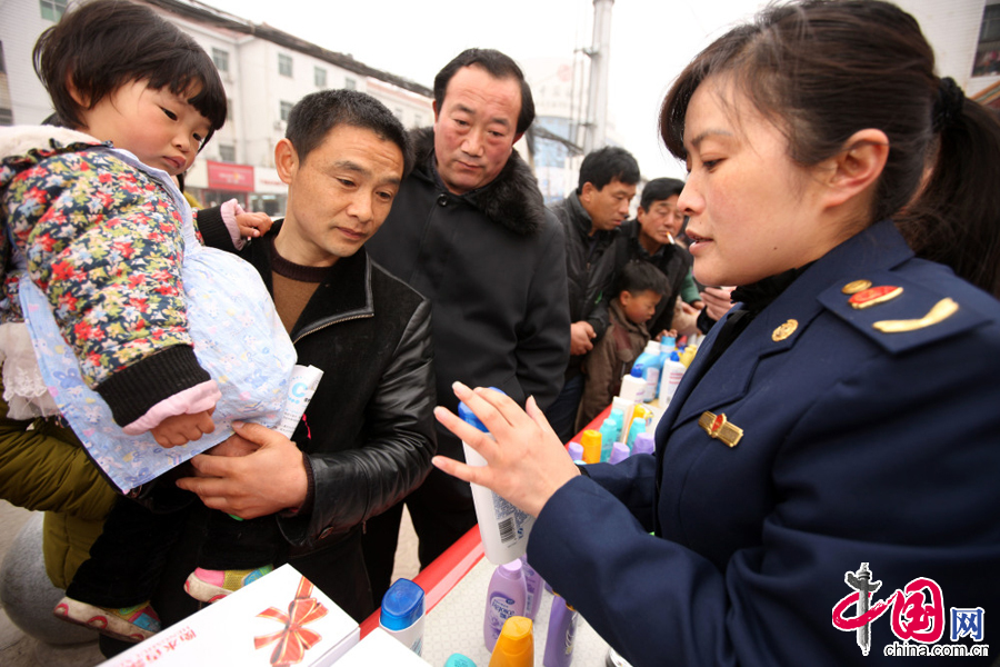圖為3月15日，安徽省蒙城縣市場監督管理局的執法人員向市民介紹假冒化粧品的識別方法。