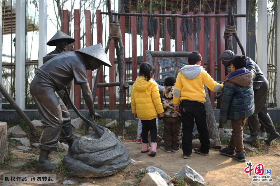 2015年3月14日，一群休息日中的小学生来到海草房前参观。中国网图片库 王海滨/摄