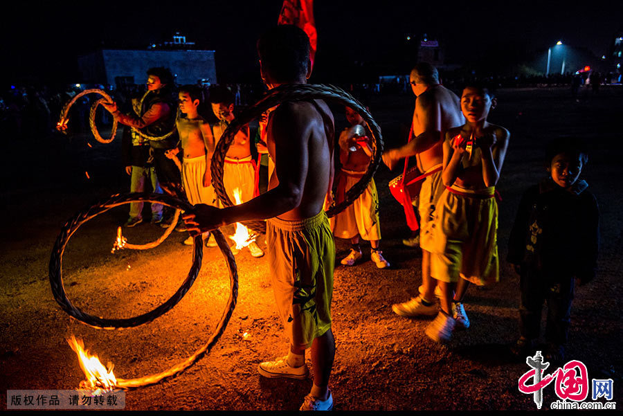 火龍出場前，火纜隊開始舞動著半圓狀的火把為火龍開道。中國網圖片庫 鄧飛/攝