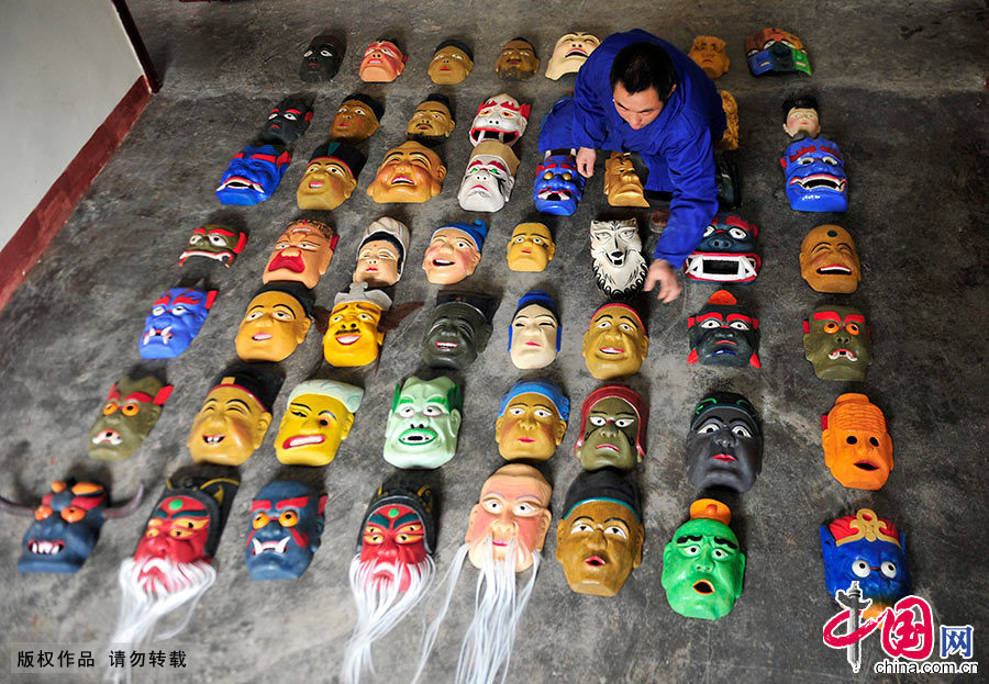  汪儒斌在整理自己雕刻的傩面具。因汪儒斌痴迷于傩面具制作，且工艺精湛，周围的邻居都亲切地称呼他为“傩面王”，加上恩施地区方言的发音，结合他本人的姓，慢慢地演变成“傩面汪”。中国网图片库 谢顺/摄