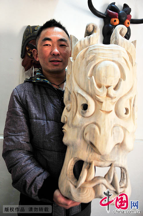 汪儒斌展示自己雕刻的傩面具。中国网图片库 谢顺/摄