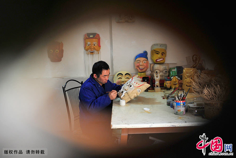 汪儒斌在为雕刻的傩面具着色。中国网图片库 谢顺/摄