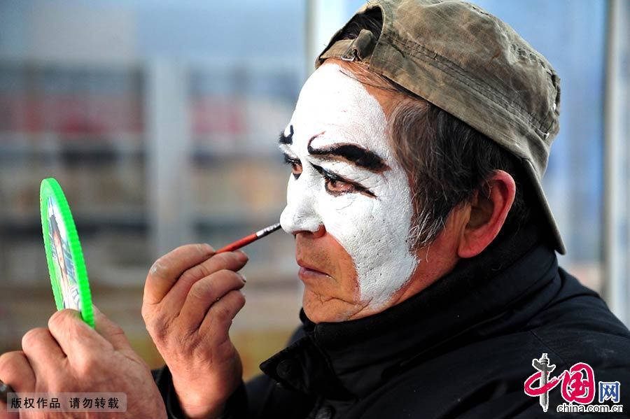 豫剧演员正在后台化妆，妆容为花脸。中国网图片库 孙凯/摄