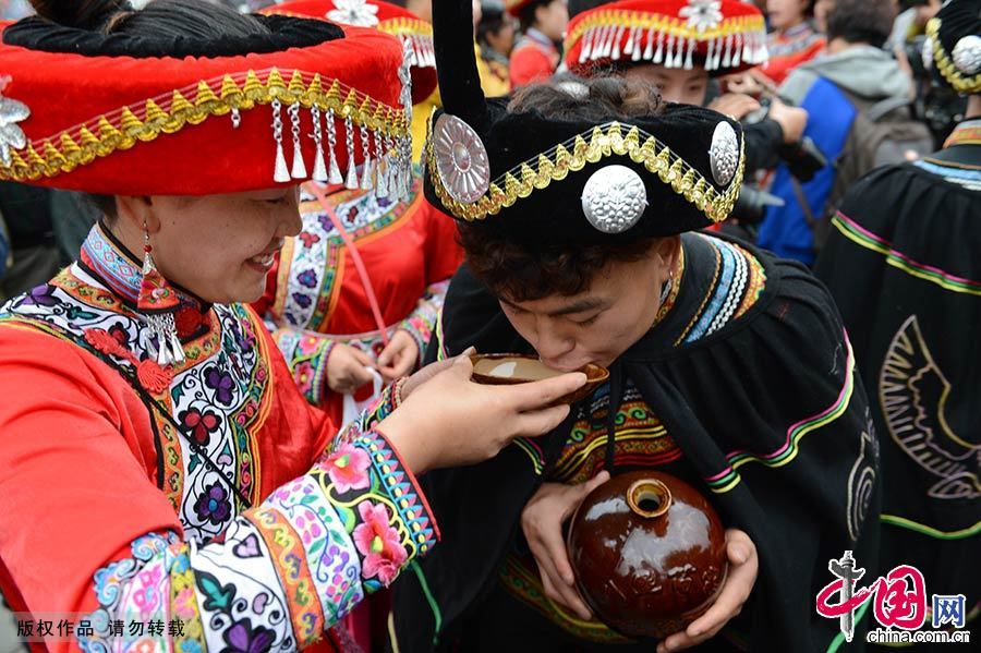  2015年3月19日，在贵州省毕节市，千余名彝族同胞聚集百里杜鹃金坡景区盛开的杜鹃花山上，参加隆重而古朴的祭花神仪式。图为彝族小伙子喝米酒。中国网图片库 彭年/摄