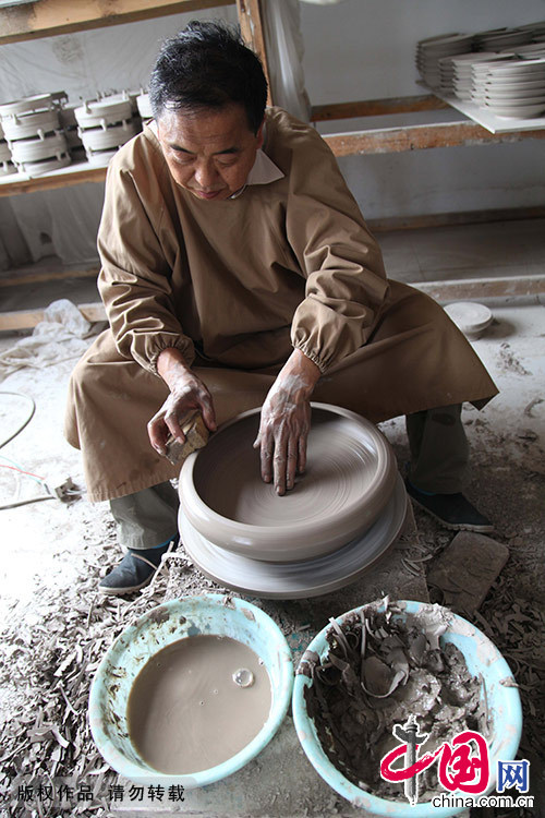 王君子将配好的胎泥，进行拉坯，制作素胎器型。中国网图片库 何五昌/摄