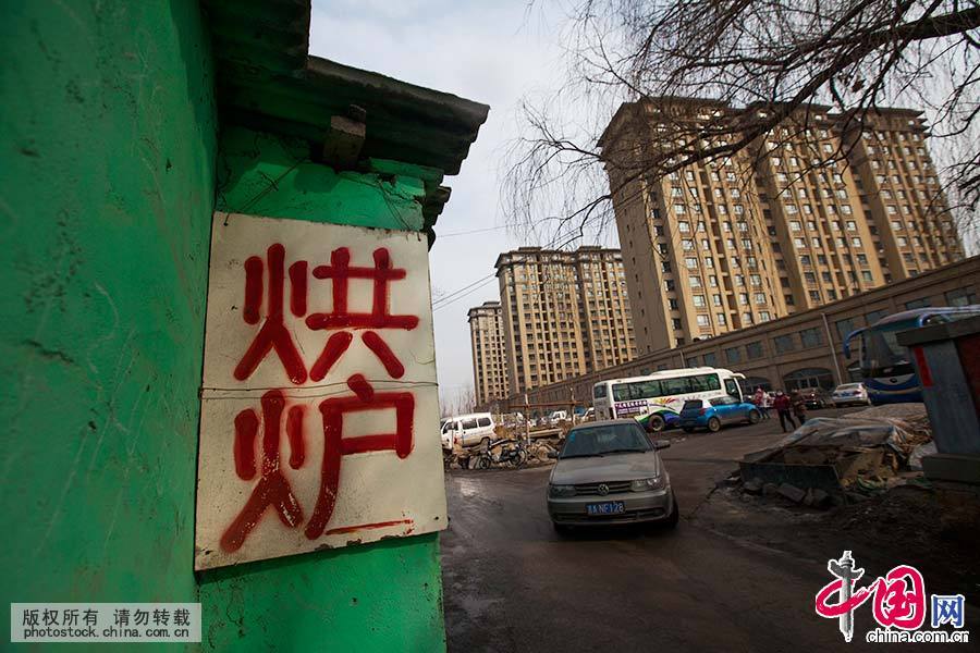  在吉林省長春市，略顯簡陋的鐵匠舖和遠處的樓房形成時代的反差。中國網圖片庫 王振東/攝