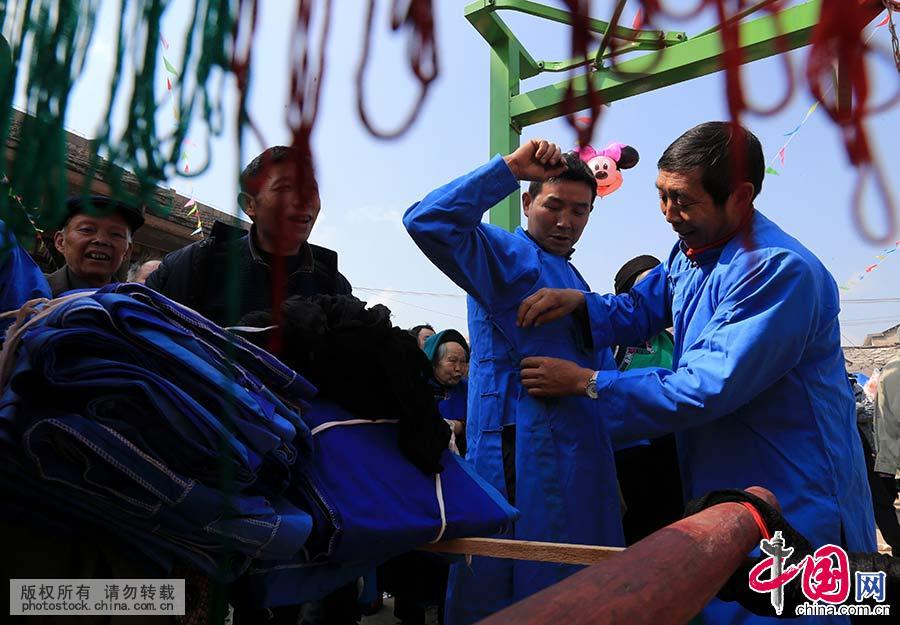 2015年2月27日，贵州省安顺市西秀区九溪村村民在“抬亭子”迎春会上，村民在相互穿戴。中国网图片库 卢维/摄 