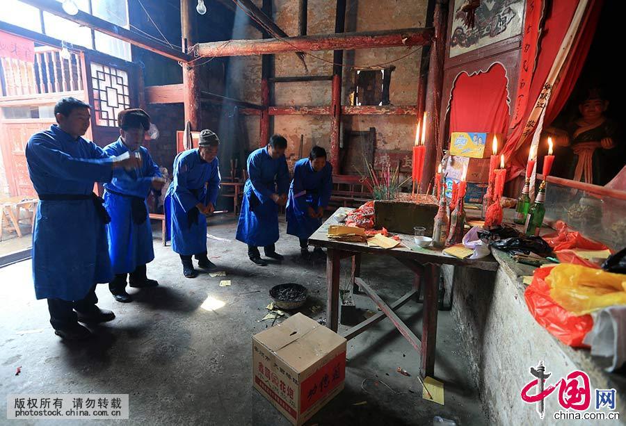 2015年2月27日，贵州省安顺市西秀区九溪村村民在“抬亭子”迎春会上，村民在“汪公”殿前祭拜，随后准备出发。中国网图片库 卢维/摄 