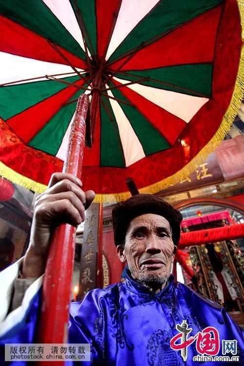 一名村民举着玉皇大帝龙头伞在巡游。中国网图片库 卢维/摄 