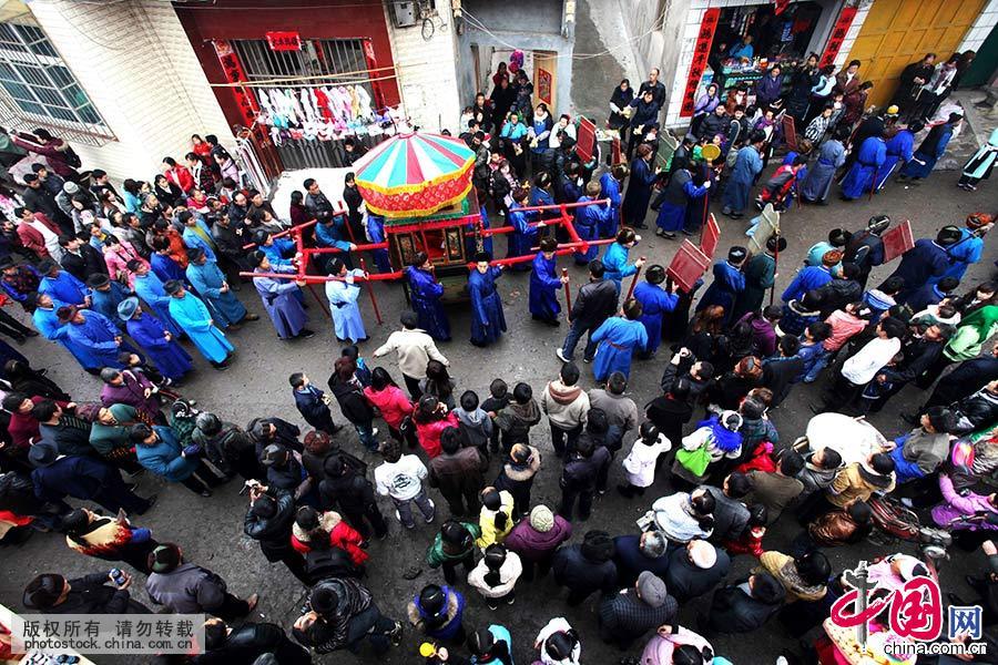 2011年2月20日，贵州省安顺市西秀区吉昌屯村举行抬亭子，村民抬着亭子在大街上游巡。中国网图片库 卢维/摄 