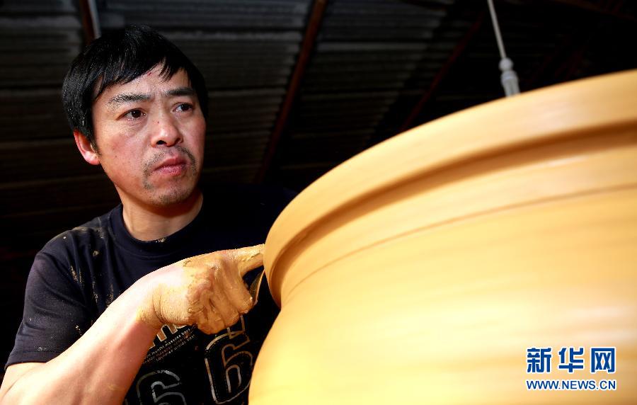 4月16日,在四川省彭州市桂花镇一家制陶厂,工人正在进行拉坯流程