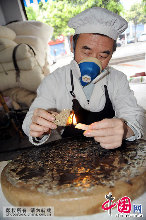 这是王定民在烤蜡制作蜡板，提升光洁度。中国网图片库 饶国君/摄