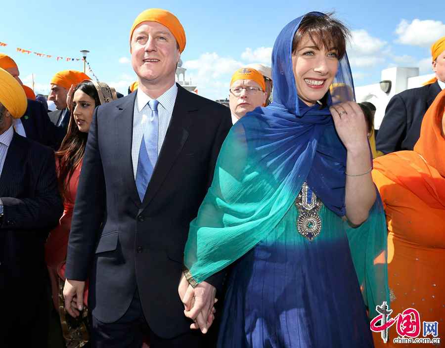  當地時間2015年4月18日，英國格雷夫森德，英國首相卡梅倫攜妻子參加錫克教Vaisakhi節日，二人身著錫克教傳統服飾，為選舉造勢。圖片來源：CFP