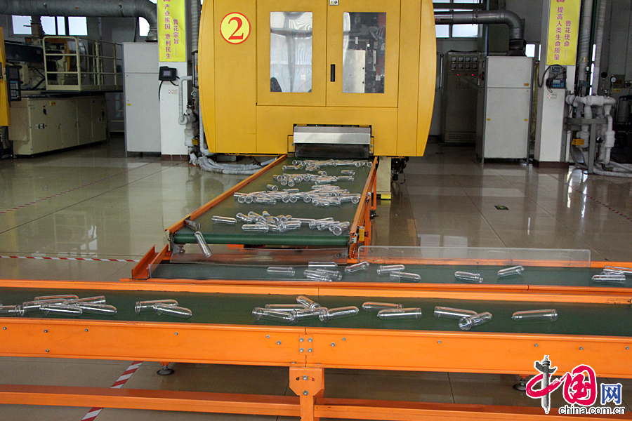 在鲁花工厂车间的食用油全自动化包装生产线上正在作业。