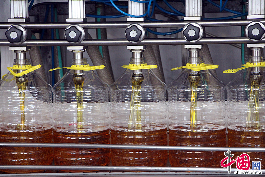 消费者购买的鲁花食用油产品正在由生产流水线自动灌装。