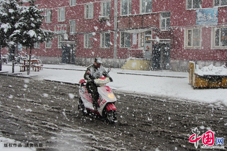 5月3日，在内蒙古牙克石市图里河镇，市民在降雪天气中出行。中国网图片库 王伟摄