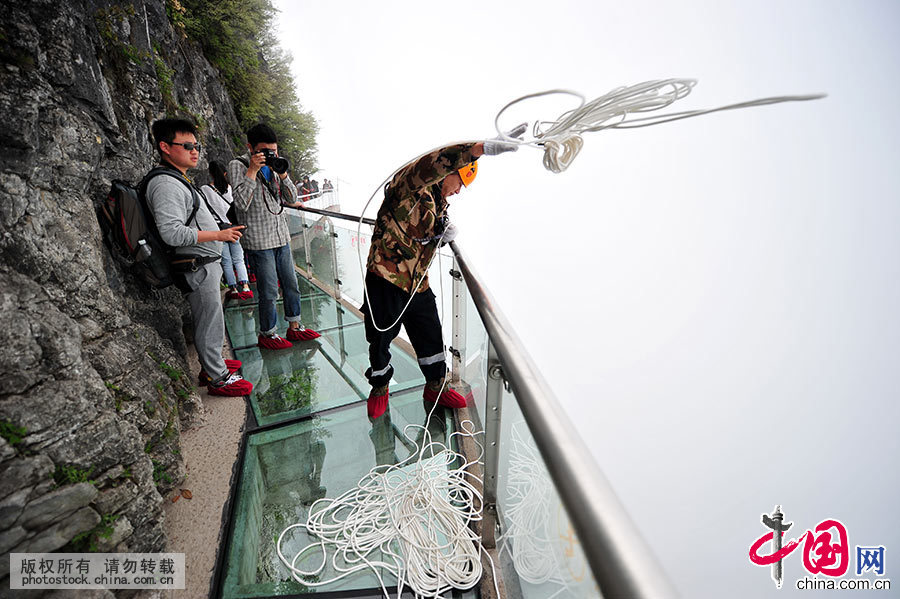 队伍里的清洁员将绳索抛给悬崖下方的朱芳幸。中国网图片库 邵颖/摄