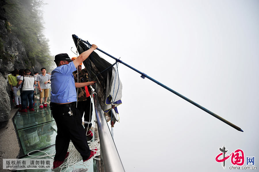 借助绳索，清洁员和工作人员合力将悬崖下方打包好的垃圾提上来。中国网图片库 邵颖/摄