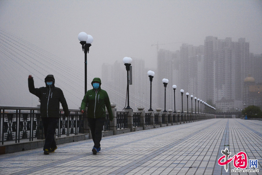 2015年5月5日，在吉林省吉林市街头，市民戴着口罩和围巾全副武装在沙尘大风天气里出行。 中国网图片库 王明铭摄影