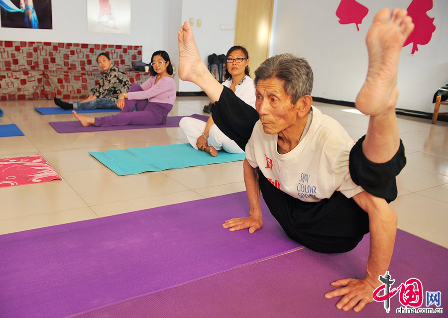 5月14日，84岁的侯振山在社区活动室为爱好者示范高难度瑜伽动作。中国网图片库 陈晓东/摄