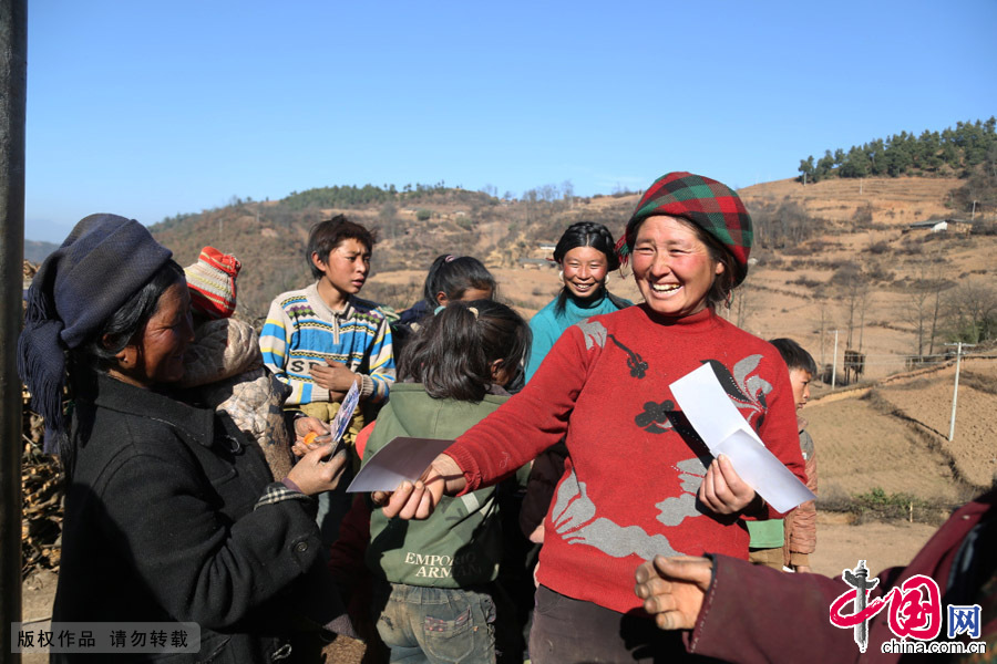 2015年1月3日，四川大涼山美姑縣馬勒故村，趙明給村民發照片。中國網圖片庫 趙明攝