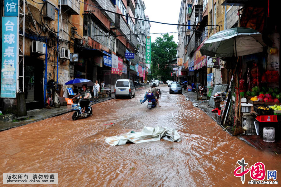 2015年6月3日，江西省德興市，市民經過被淹的街道。中國網圖片庫 東方攝