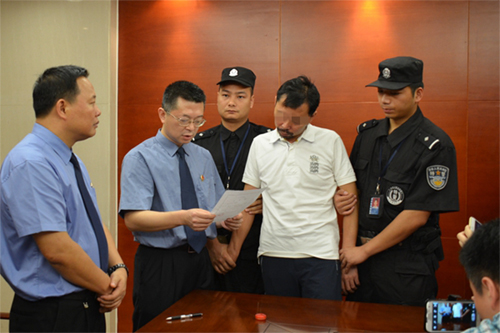 檢察機關向祁某某（左四）宣佈刑事拘留決定