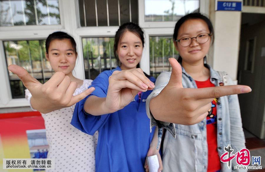 6月7日，在河北省邯郸市第一中学考点，三名考生摆出“678”的手势，寓意“录取吧”。中国网图片库 郝群英 摄