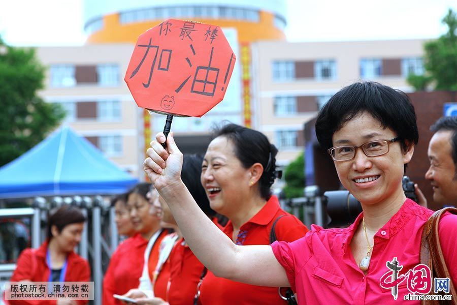 2015年6月7日，上海七宝中学考点，一位身着红衣的老师为学生加油。中国网图片库 王亚东 摄