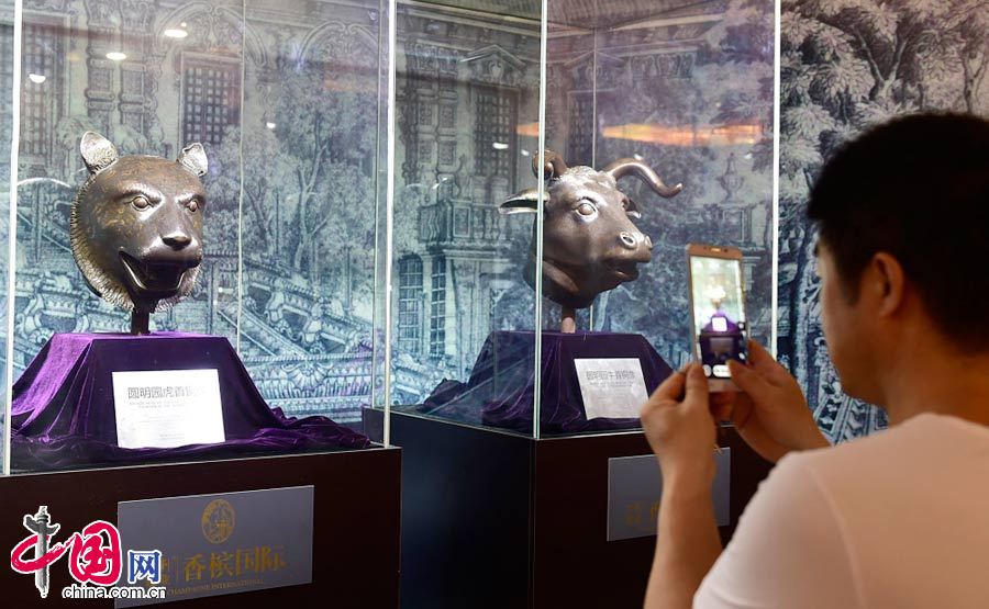 2015年6月13日，河南洛阳，观众在《圆明园国宝展》活动现场，参观圆明园十二生肖兽首“虎首”、“牛首”铜像。