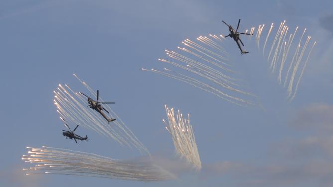 Russian Mi-28 military helicopters fly during the opening of the Army-2015 international military forum in Kubinka