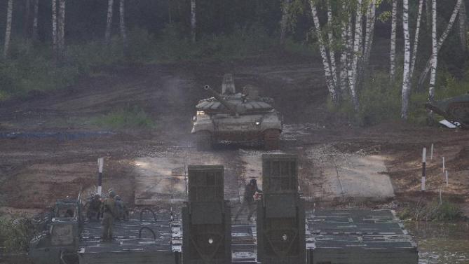 A Russian tank prepares to be taken across the river during the Army-2015 show at a shooting range in Alabino, outside of Moscow, Russia, on Tuesday, June 16, 2015. Russia’s military this year alone will receive over 40 new intercontinental ballistic missiles capable of piercing any missile defences, President Vladimir Putin said Tuesday in a blunt reminder of the nation’s nuclear might amid tensions with the West over Ukraine. (AP Photo/Ivan Sekretarev)