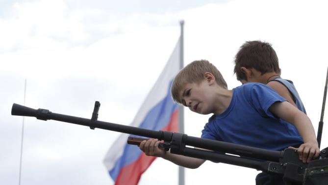 Boys inspect an exhibit as they visit the Army-2015 international military-technical forum in Kubinka