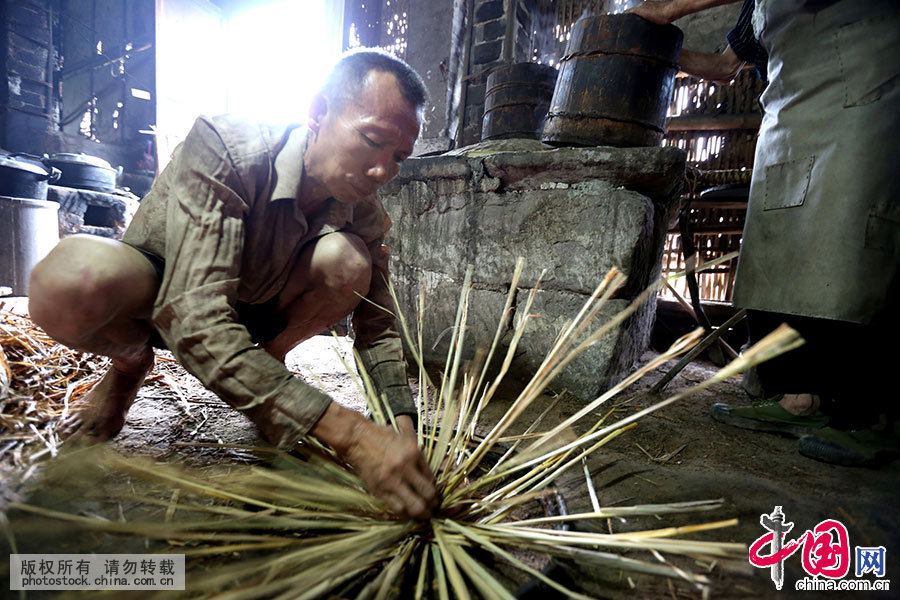 杨辉刚的大儿子在用稻草编织油饼套子。中国网图片库 邱海鹰/摄