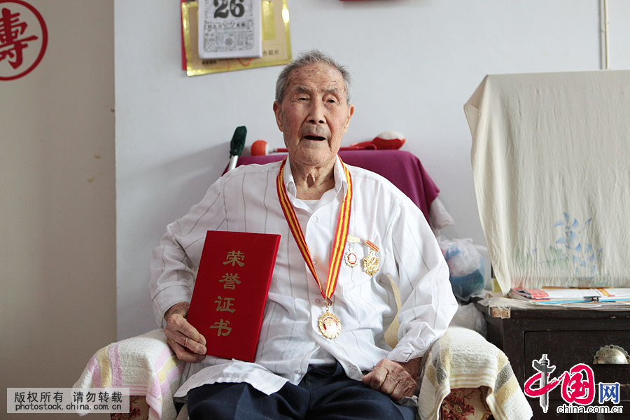 102歲的郭老70年前的身份是農村教師，實際上他已是一名中共地下黨員。2005年中共中央、國務院、中央軍委給郭憲同頒發有“紀念中國人民抗日戰爭勝利六十週年”紀念勳章一枚。中國網圖片庫 楊俊琦攝