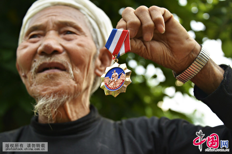 曾慶平向我們展示他的抗日英雄紀念章。中國網圖片庫 羅星漢攝