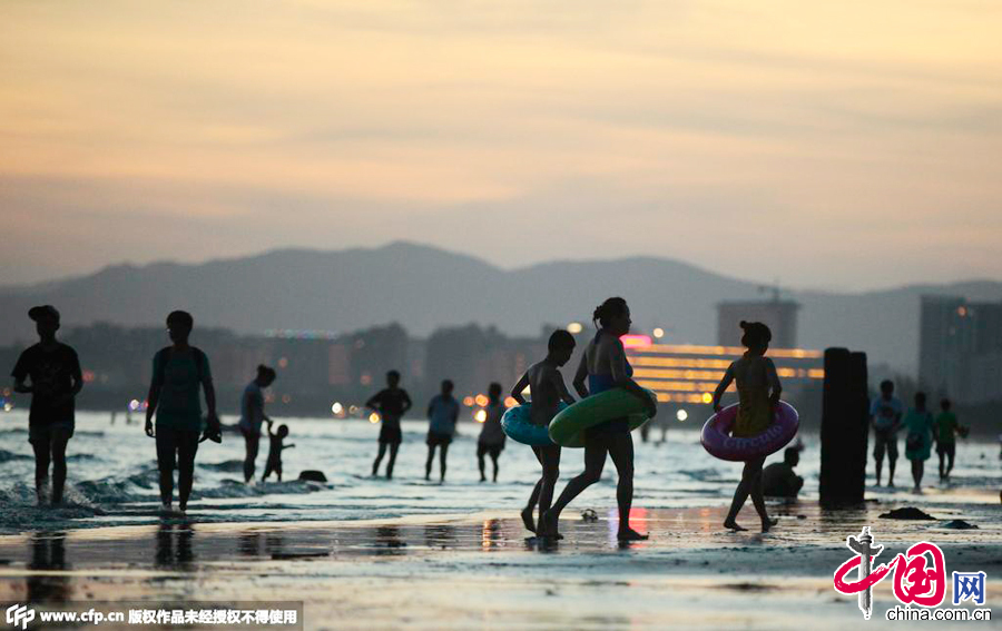2015年07月02日，海南三亞，人們在三亞灣海邊戲水消暑。 圖片來源：CFP