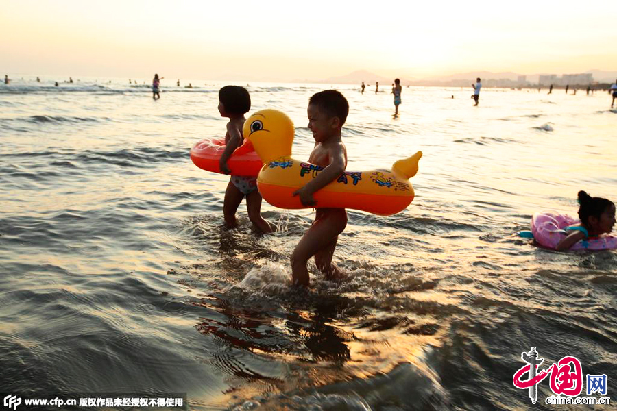 2015年07月02日，海南三亚，人们在三亚湾海边戏水消暑。 图片来源：CFP