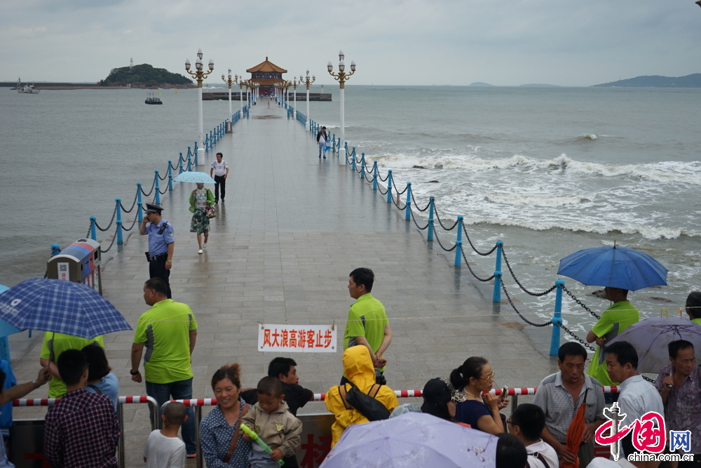  7月12日，山东青岛，第9号台风“灿鸿”全面影响青岛。沿海景区看到，受到台风影响，几米高的海浪不断击打岸边。栈桥及青岛各大海水浴场拉起游客警示牌，暂停开放。