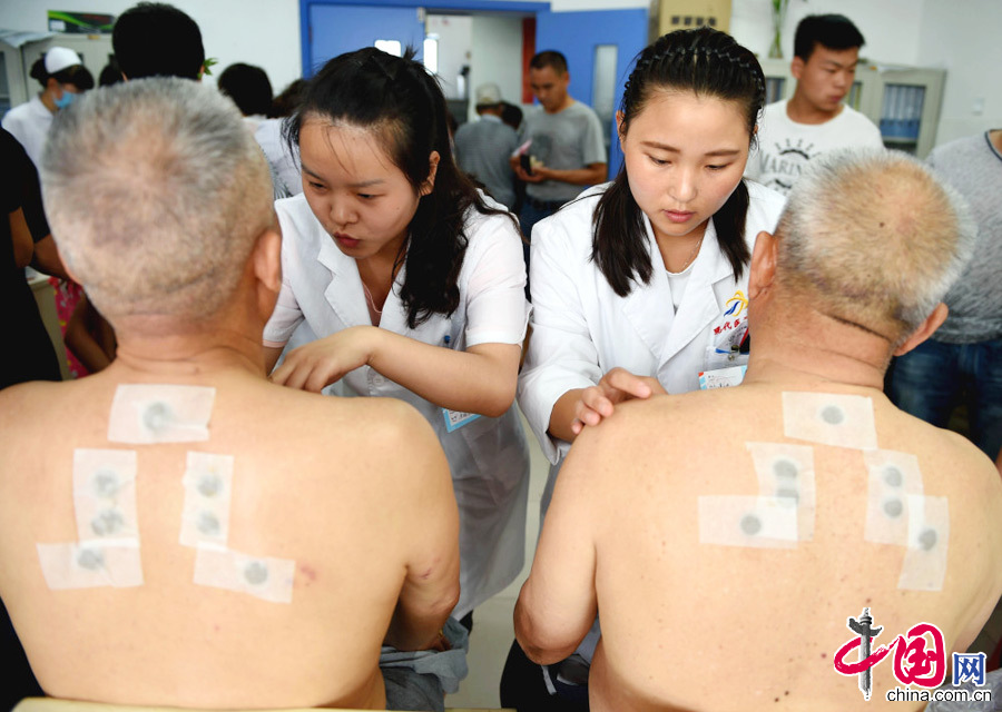 7月13日，安徽省亳州市華佗中醫院，市民在貼三伏貼。