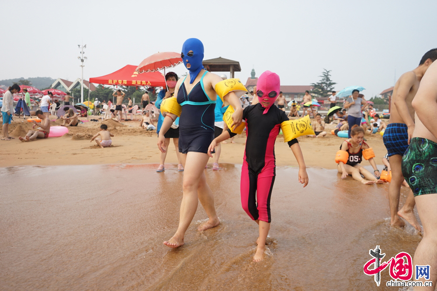 2015年7月13日，青岛第一海水浴场，脸基尼已经不再是青岛大妈的专利，在青岛第一海水浴场，还出现了期“脸基尼”亲子套装，年轻的妈妈带着自己的孩子，着“脸基尼”亲子套装引领别样时尚。