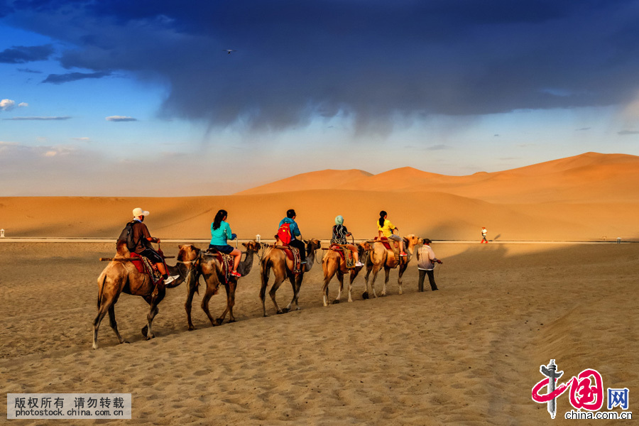 鸣沙山，骑骆驼观光的人们。中国网图片库 刘国兴摄