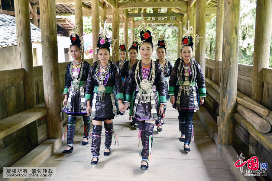 来宰荡侗寨“吃相思”的侗族姑娘走过花桥。中国网图片库 王炳真摄